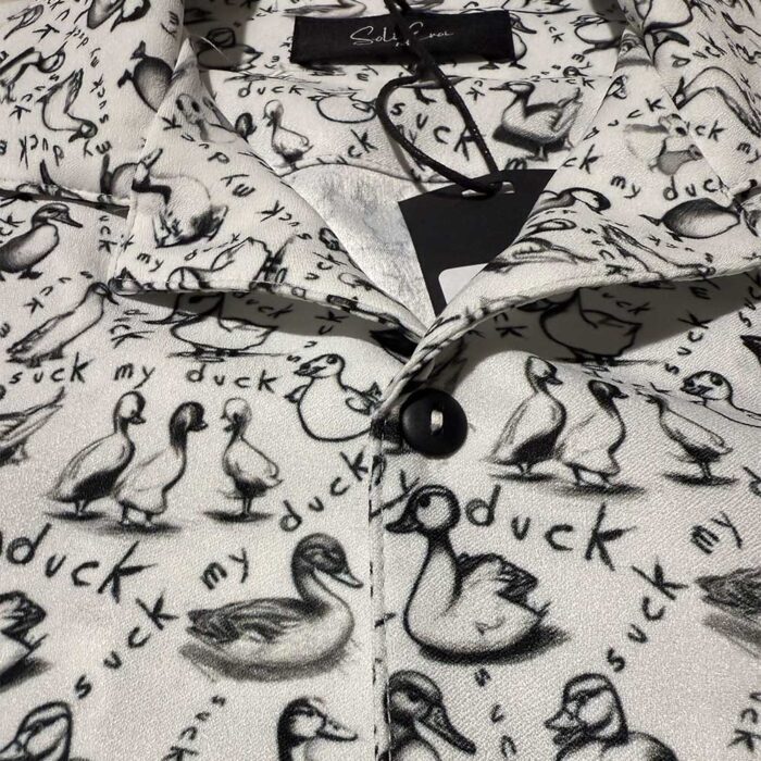 Unisex κοντομάνικο πουκάμισο Soli Eroi "Suck My Duck" σε μαύρο και λευκό με print παπάκια, ελληνικής κατασκευής.
