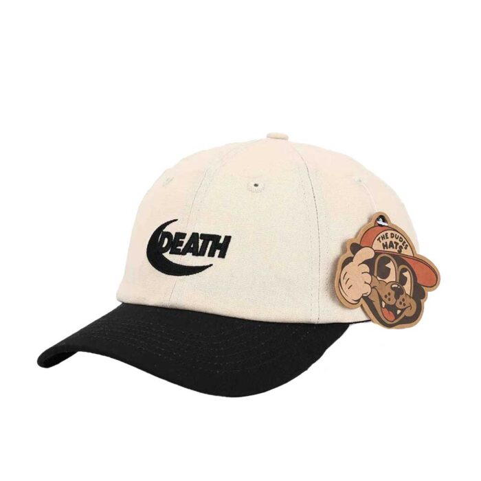 The Dudes Death Dad Cap Off White με κεντημένο σχέδιο DEATH από McBess, βαμβακερό ύφασμα και ρυθμιζόμενο κλείσιμο με μπρούτζινη αγκράφα.